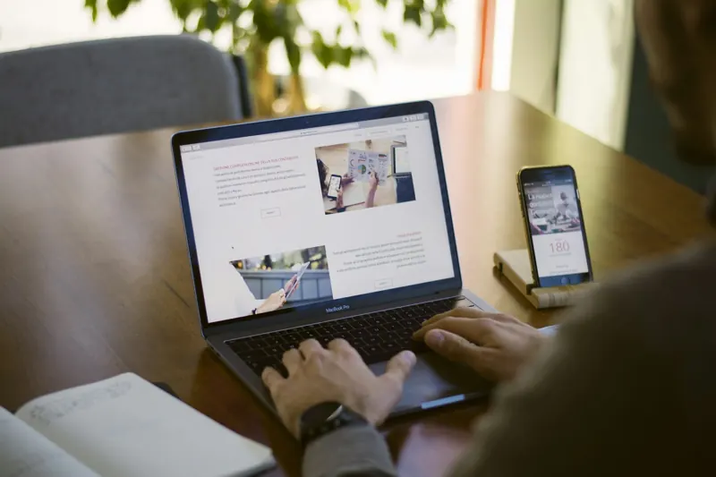 Laptop met een website, en een telefoon op tafel